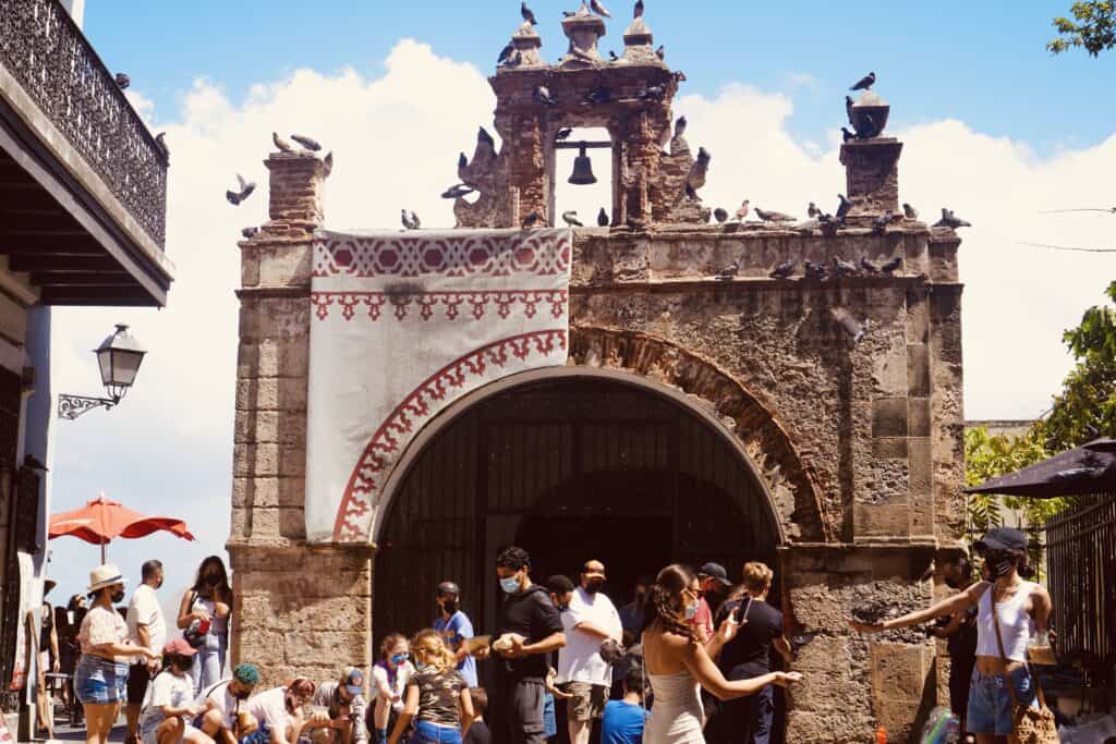 Exterior of Capilla del Santo Cristo de la Salud with many tourists outside of it.