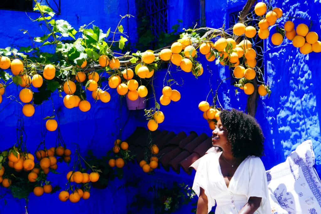 Woman next to oranges in Chefchaouen
